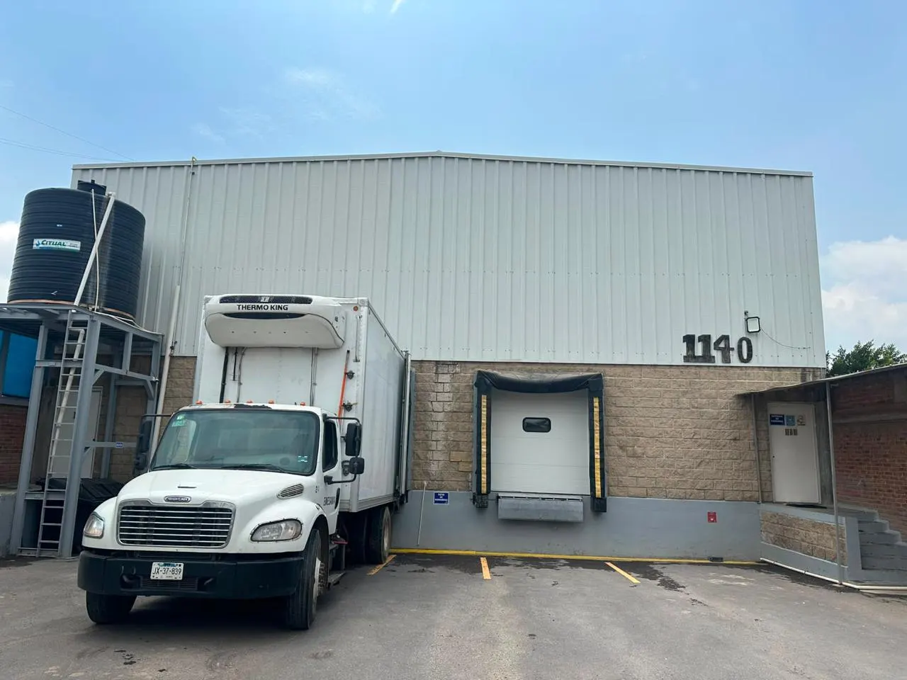 Planta de Puente Viejo en Tonalá con un camión de caja refrigerada acoplado al andén de embarque.